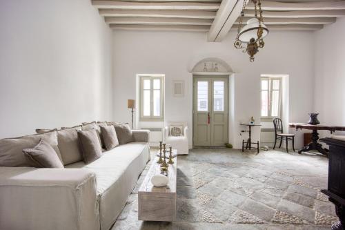 Una sala de estar blanca con un sofá y una mesa. en Folegandros Chora Bliss by Estia, en Chora Folegandros