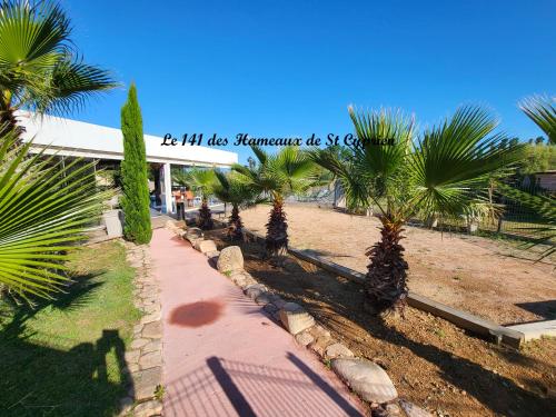 une rangée de palmiers devant un bâtiment dans l'établissement Joli T2 climatisé au calme à 10 mm de Porto-Vecchio dans une résidence de tourisme, à Lecci