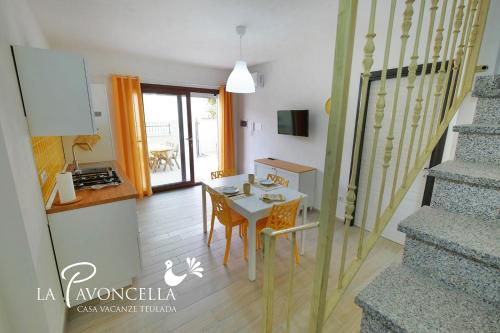 a kitchen and a dining room with a table at Case Vacanze La Pavoncella in Teulada