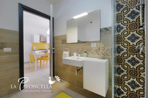 a bathroom with a sink and a mirror at Case Vacanze La Pavoncella in Teulada