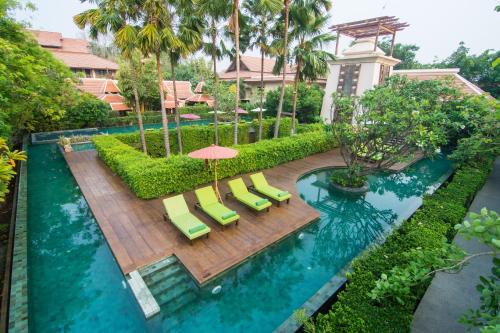 an overhead view of a pool with chairs and an umbrella at Siripanna Villa Resort & Spa Chiang Mai -SHA Extra Plus in Chiang Mai