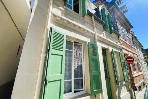 un bâtiment avec volets verts et fenêtre dans l'établissement Nice house near hypercenter, à Trouville-sur-Mer