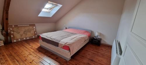 une chambre avec un lit et une lucarne dans l'établissement Maison Saint Pavin, au Mans