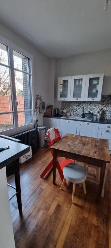 Il comprend un salon avec une table en bois et une cuisine. dans l'établissement Maison Saint Pavin, au Mans