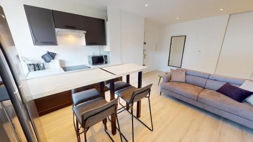 une cuisine et un salon avec une table et un canapé dans l'établissement Coloc Madia I Lot 2, à Annemasse