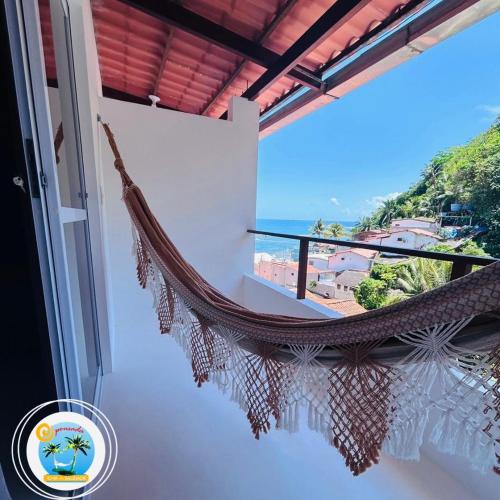 a hammock on a balcony with a view of the ocean at Pousada Ilha da Saudade in Morro de São Paulo