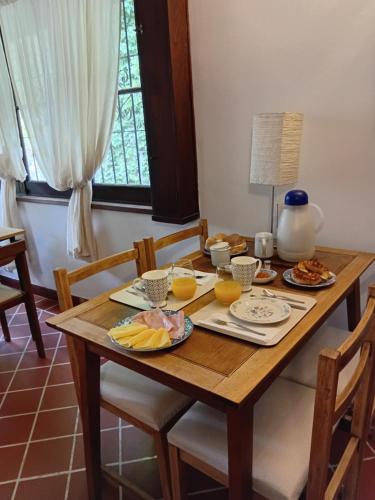 een houten tafel met eten en sinaasappelsap erop bij Chalet Las Nenas B&B in Mar del Plata