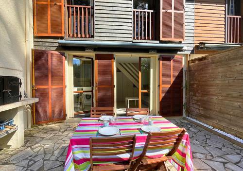 - un patio avec une table et deux chaises et un bâtiment dans l'établissement SYLVICULTEURS - Charmante villa patio rénovée, à Seignosse