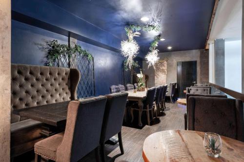 a dining room with tables and chairs and blue walls at The O Hotel, Trademark Collection by Wyndham in Los Angeles