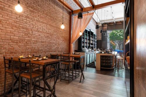 a restaurant with wooden tables and a brick wall at The O Hotel, Trademark Collection by Wyndham in Los Angeles