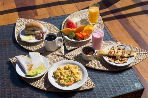 Garden House - Ilha do Guajiru في إيتاريما: طاولة مع أطباق من طعام الإفطار ومشروب