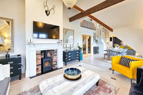 a living room with a fireplace and a yellow couch at Exclusive 3 Bedroom Penthouse - 2 Bath & Mezzanine in Harrogate