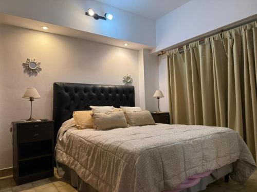 a bedroom with a large bed with a black headboard at Paraíso Costero San Bernardo in San Bernardo