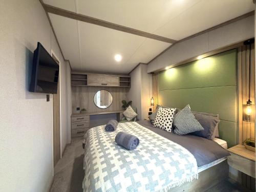 a bedroom with a large bed and a flat screen tv at Skye View Lodge in Filey