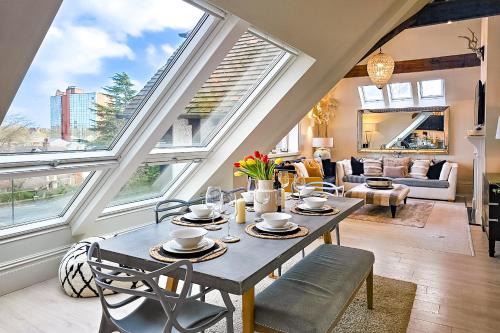 a living room with a table and some windows at Exclusive 3 Bedroom Penthouse - 2 Bath & Mezzanine in Harrogate