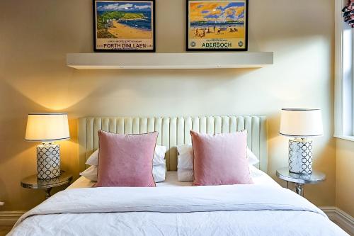 a bedroom with a bed with pink pillows and two lamps at Exclusive 3 Bedroom Penthouse - 2 Bath & Mezzanine in Harrogate