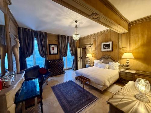 a bedroom with a bed and a chair and a table at Demeure des Vieux Bains in Provins