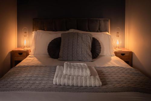 a bed with a white blanket and pillows and two lamps at Central Llandeilo with Stunning views- Sleeps 2 in Llandeilo
