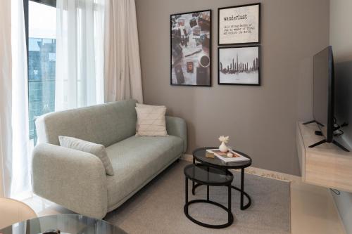 uma sala de estar com um sofá e uma TV em Keyrock Living - Elegant City Escape at Zada Tower no Dubai