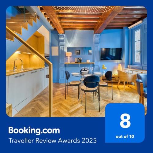 une cuisine avec des murs bleus et une table et des chaises dans l'établissement Les Loges Saint Éloi Somptueux F4 pour 7 personnes, à Rouen