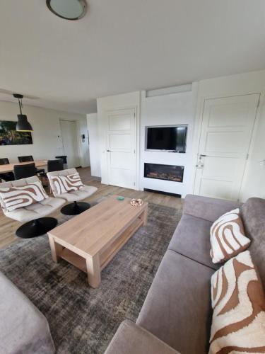 ein Wohnzimmer mit Sofas und einem Couchtisch in der Unterkunft Waterresort Bodelaeke Giethoorn in Giethoorn