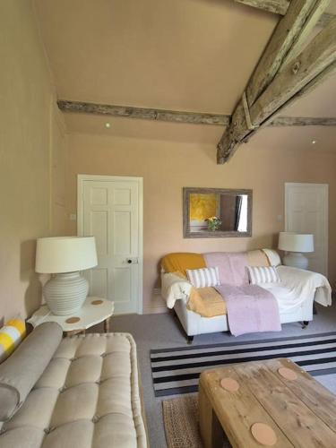 a bedroom with two beds and a couch and a table at Little Plas in Crickhowell