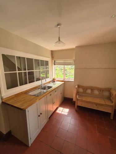 a kitchen with a sink and a bench in it at Little Plas in Crickhowell