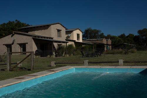 a swimming pool in front of a house at Cabaña Atardecer - Finca La Falda - Salta in Cerrillos