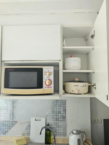 a microwave oven sitting on top of a kitchen counter at Apartment near Central phuket in Phuket