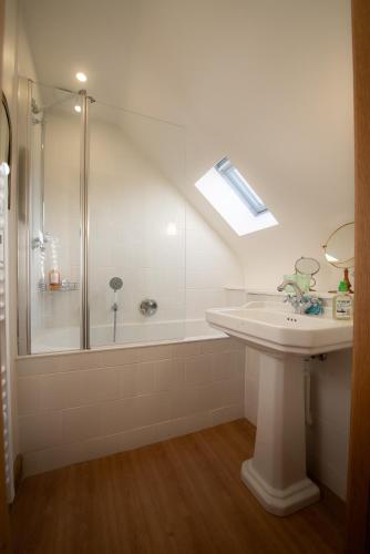 une salle de bain blanche avec une douche et un lavabo dans l'établissement Closerie de La Salière, gîte de charme et chambres d'hôtes, châteaux de la Loire, zoo de Beauval, à Le Controis En Sologne