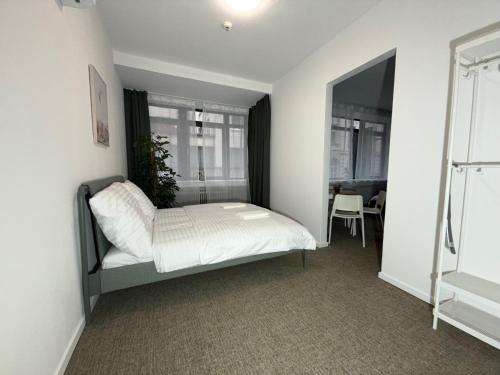 a bedroom with a bed with white sheets and a window at Gremium Apartments in Bratislava
