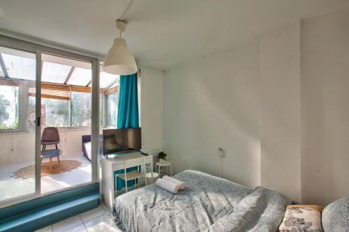 une chambre avec un lit, une télévision et une fenêtre dans l'établissement Chic and spacious apart amaizing terrace, Évry-Courcouronnes