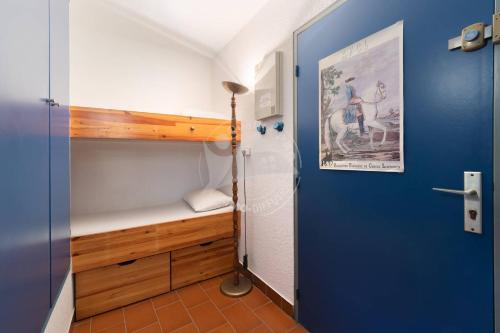 Cette chambre comprend des lits superposés et une porte bleue. dans l'établissement AS4269 - Studio cabine direct sur plage vue mer et parking privé et numéroté, au Grau-du-Roi