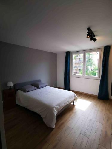 une chambre avec un lit blanc et une fenêtre dans l'établissement T1 bis à deux pas du Belvédère, à Thonon-les-Bains
