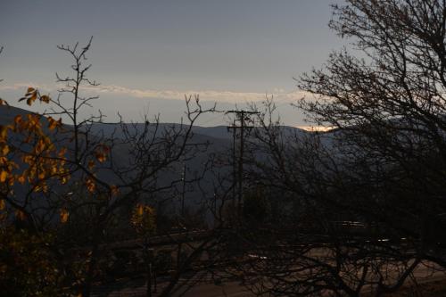 a view of the mountains from behind some trees at Boutique Arachova Retreat - Peaceful Mountain View in Arachova