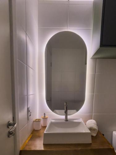a bathroom with a sink and a mirror at Tropical apartament in São Paulo