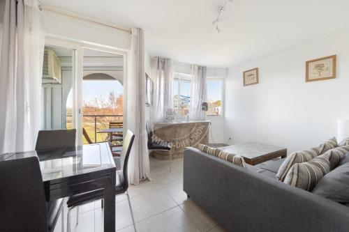 un salon avec un canapé et une table dans l'établissement AS17563 - P2 Entièrement équipé accès mer direct avec parking privé, au Grau-du-Roi