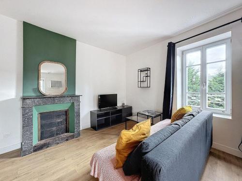 un salon avec un canapé bleu et une cheminée dans l'établissement Apartment Gare 4 pers N5, à Clermont-Ferrand