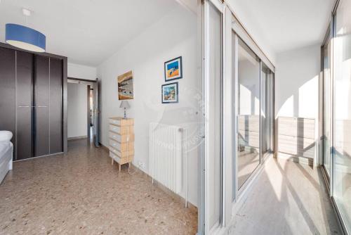 - une chambre avec des murs blancs et une grande fenêtre dans l'établissement AS17006 - P3 Vue mer face à la plage sans route à traverser et proche centre ville, au Grau-du-Roi