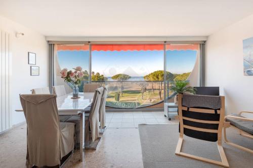 une salle à manger avec une table et une grande fenêtre dans l'établissement AS17006 - P3 Vue mer face à la plage sans route à traverser et proche centre ville, au Grau-du-Roi