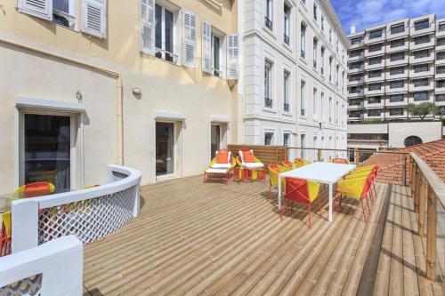 une terrasse en bois avec des chaises et une table sur un balcon dans l'établissement REF 1208 - Cannes - 5mins to Palais des Festivals, à Cannes