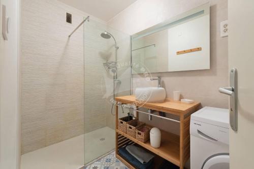 une salle de bain avec une douche en verre et un lavabo dans l'établissement AS13357 - P3 face à la plage sans route à traverser, proche centre ville avec parking privé, au Grau-du-Roi