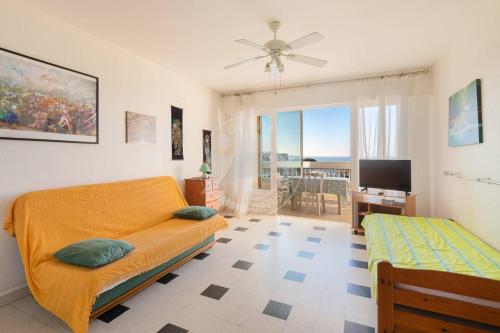 une chambre avec un lit, une télévision et un canapé dans l'établissement AS16246 - Studio au Boucanet avec magnifique vue mer, au Grau-du-Roi