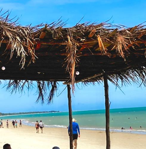 a group of people walking on a beach at Sabiá & C0 Casa Hotel Suítes in Prado
