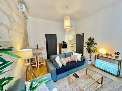 un salon avec un canapé bleu et une cuisine dans l'établissement Beaux T2 et T3 climatisés dans le triangle d'or, à Bordeaux
