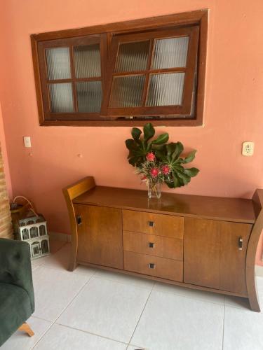 a vase of flowers on a dresser in a room at Sabiá & C0 Casa Hotel Suítes in Prado