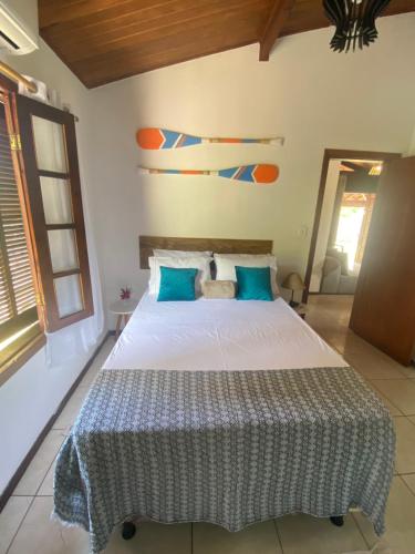 a bedroom with a large white bed with blue pillows at Sabiá & C0 Casa Hotel Suítes in Prado