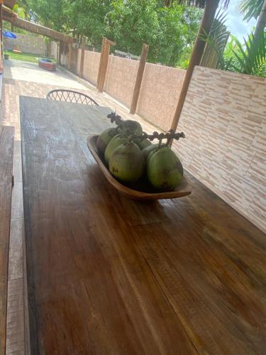 a bowl of green coconuts on a wooden table at Sabiá & C0 Casa Hotel Suítes in Prado