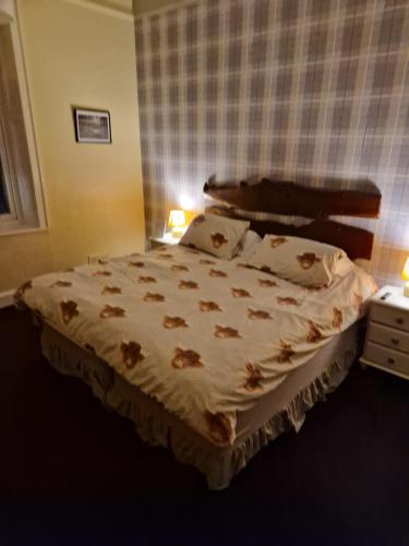a bedroom with a large bed in a room at Neidpath Inn in Peebles