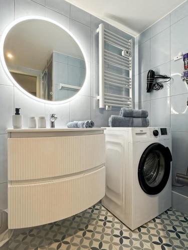 a bathroom with a washing machine and a mirror at Charmant studio avec parking in Eguisheim